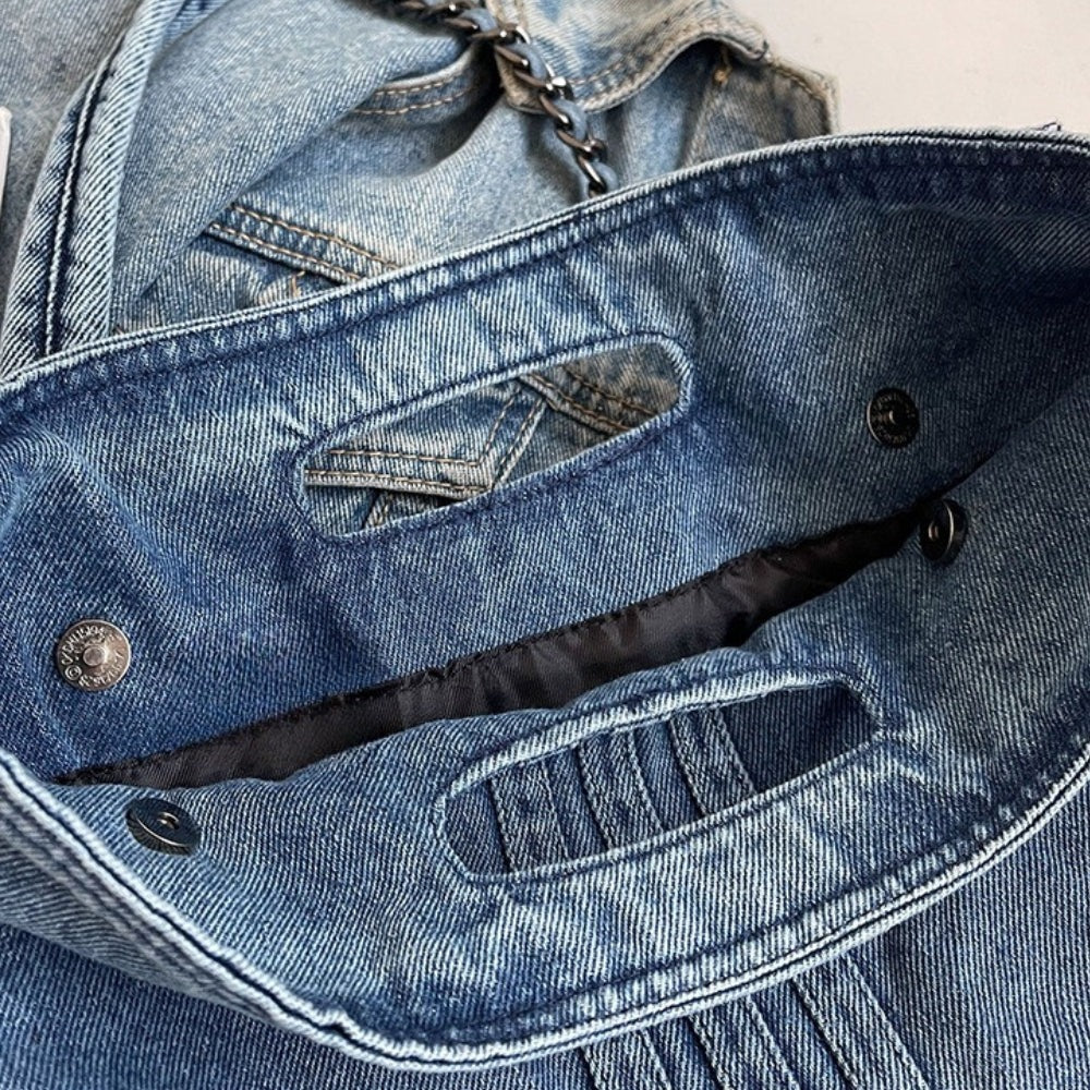 Rabat relevé sur ses boutons pression et sa doublure sombre, fausse poche en denim surpiquée