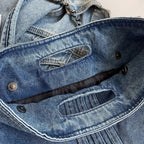 Rabat relevé sur ses boutons pression et sa doublure sombre, fausse poche en denim surpiquée
