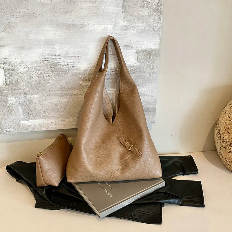 Mise en scène du hobo taupe avec sa pochette, devant une toile grise et un livre fermé