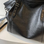 Détail du cuir végan noir froissé, rivets en forme d'étoile et attache de bandoulière