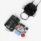 Mise à plat du cabas noir et de son contenu : téléphone, pochette, rouge à lèvres et miroir