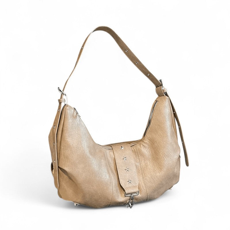 Beige sable patiné pour ce hobo croissant, sangle fine et rangée de clous étoile, vu de face