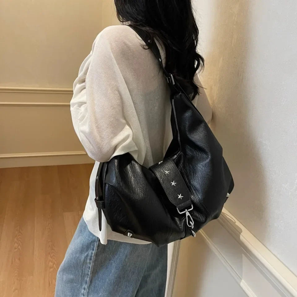 Portée à l'épaule sur un pull écru, la déclinaison noire garde sa forme arrondie et souple