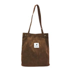 Tote bag en velours côtelé marron, vu de face, longues anses et étiquette brodée