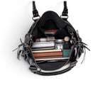 Plongée dans le sac ouvert, garni de cahiers, d'une trousse et de produits de beauté rangés debout
