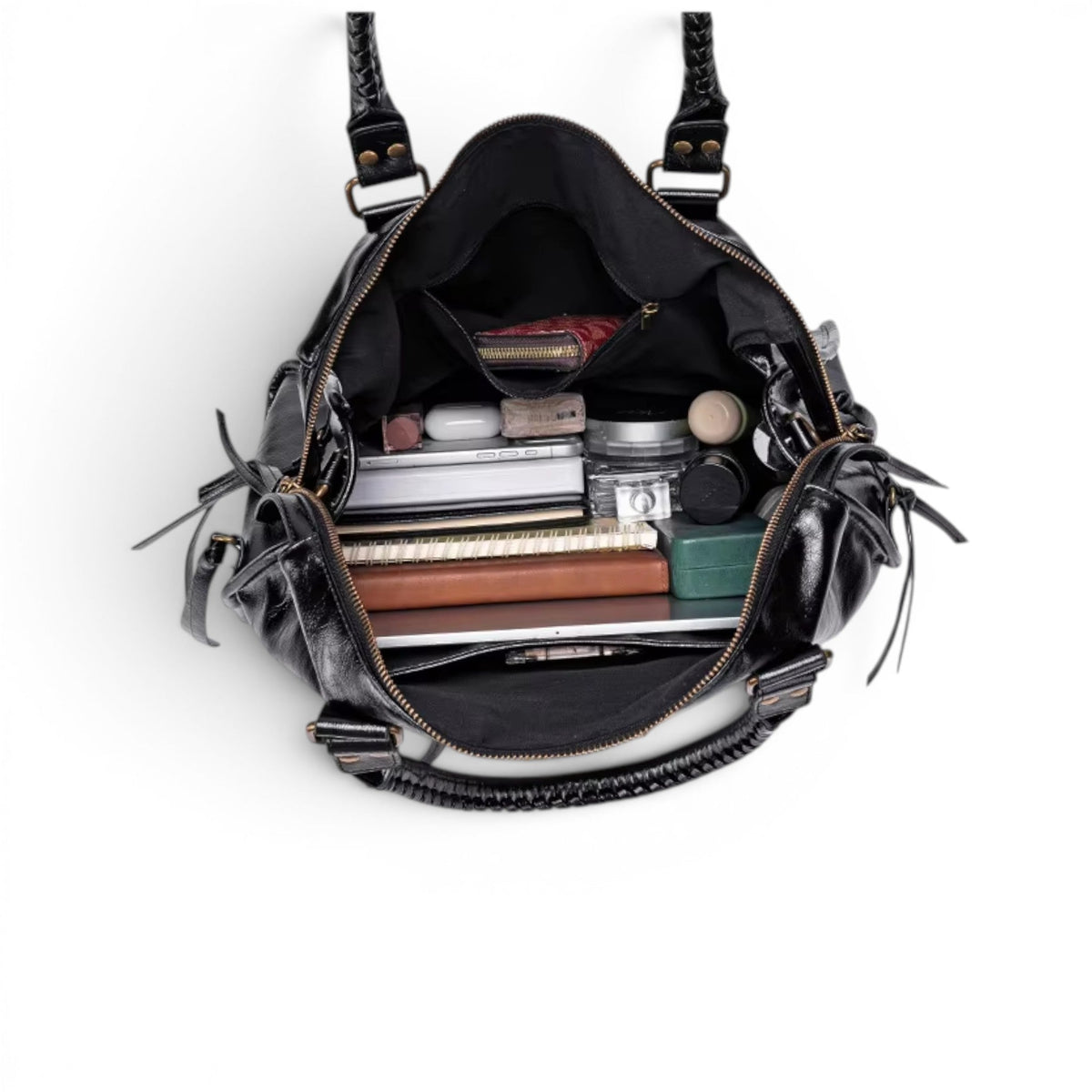 Plongée dans le sac ouvert, garni de cahiers, d'une trousse et de produits de beauté rangés debout