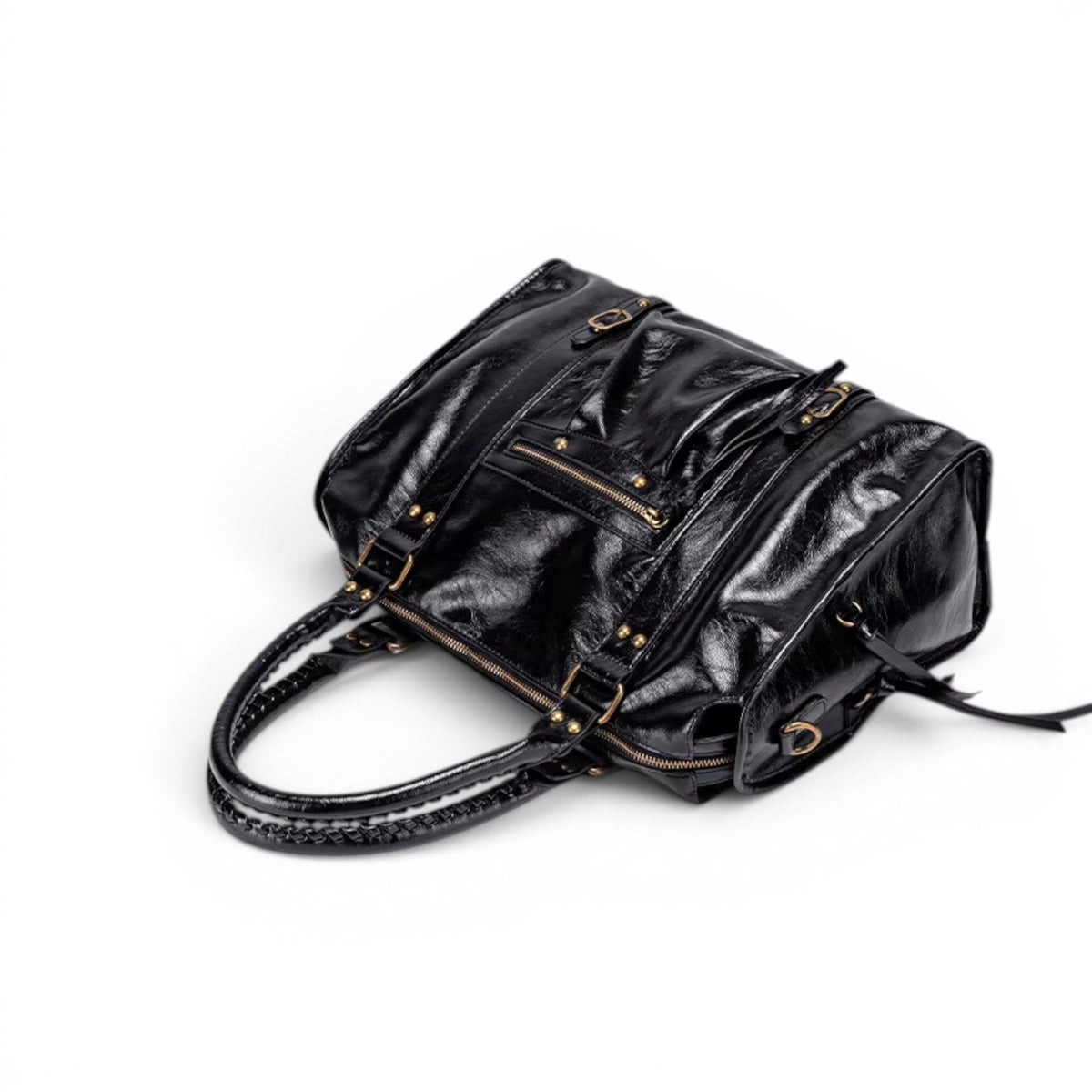 Pris de dessus, le sac noir laisse voir sa fermeture à glissière supérieure et ses anses tressées