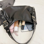 Ouverture zippée du sac noir, trousse rose, flacons de soin et téléphone glissés à l'intérieur