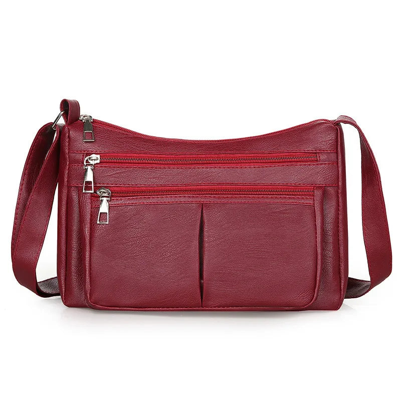 Coloris rouge bordeaux, poches zippées superposées et bandoulière assortie sur toute la largeur