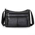 Petit sac bandoulière noir à double glissière, poche plaquée centrale et sangle large réglable