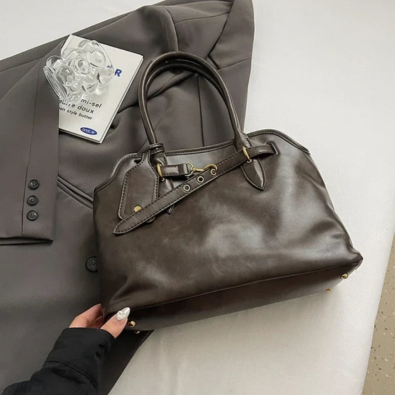 Posé sur une veste grise, le cabas brun café révèle son cuir végan lustré et ses pieds métal