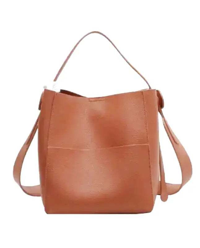 Cuir végan lisse cognac clair sur ce sac seau de face, nœuds latéraux et poche frontale