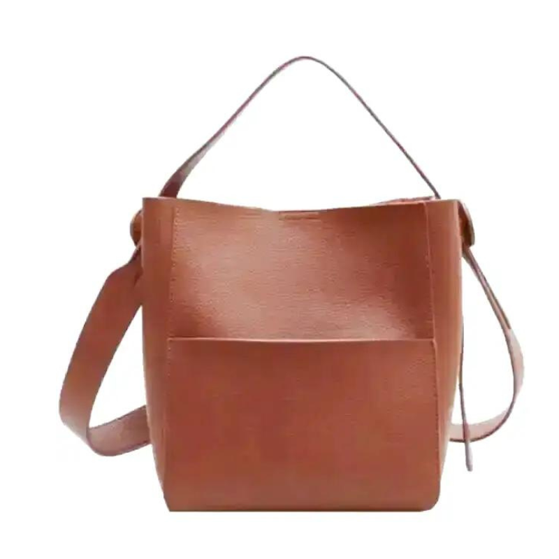 Sac seau en cuir végan cognac, vu de face, poche plaquée et large bandoulière réglable