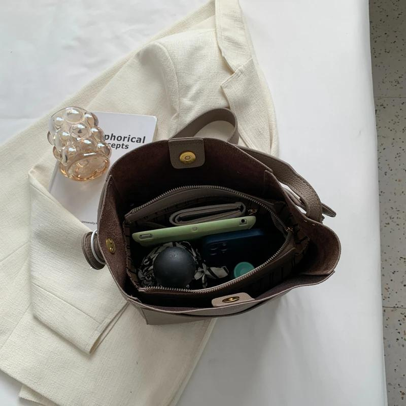 Intérieur du sac ouvert, doublure sombre et affaires du quotidien rangées au fond