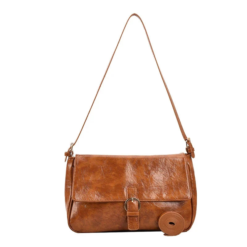 Cognac lumineux pour cette besace à rabat, passant de sangle et boucle métal dorée, présentée seule