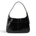 Besace d'épaule en cuir végan lustré noir, anse simple et boucle dorée réglable sur le côté