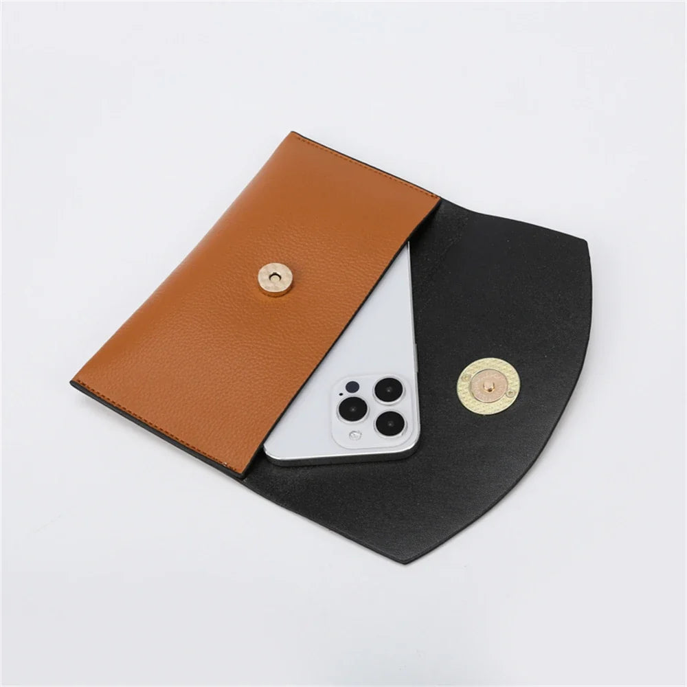 Pochettes cognac et noire ouvertes côte à côte, un téléphone glissé dans la plus grande