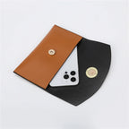 Pochettes cognac et noire ouvertes côte à côte, un téléphone glissé dans la plus grande