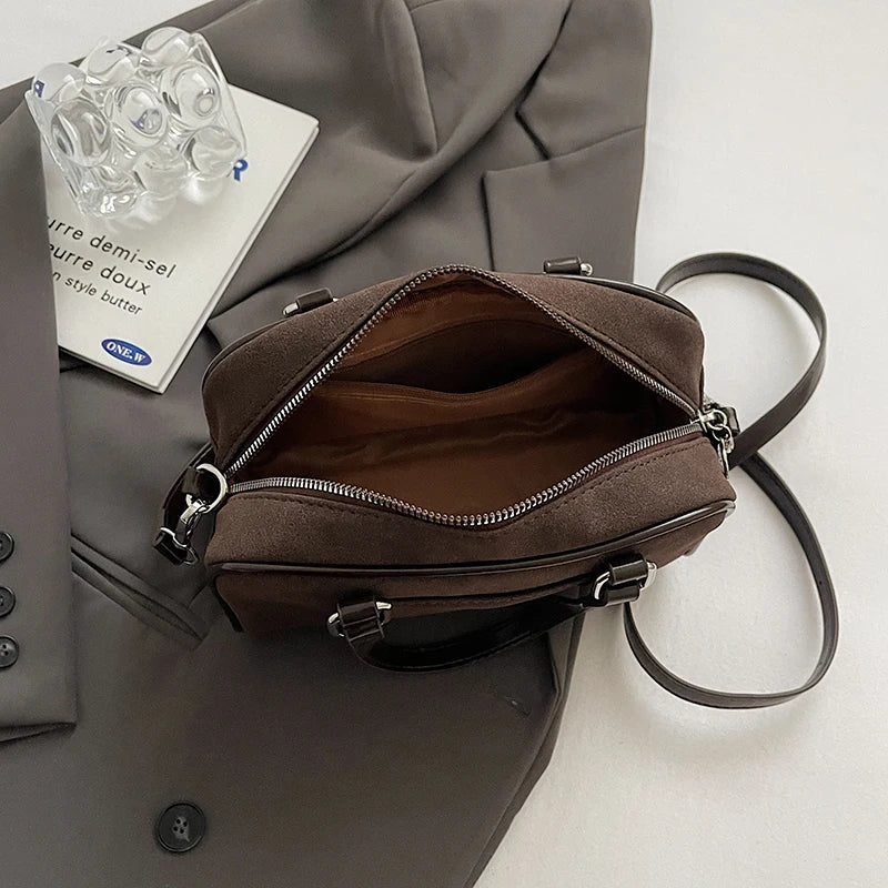 Intérieur du sac marron entrouvert, doublure assortie, glissière métallique et bandoulière détachée