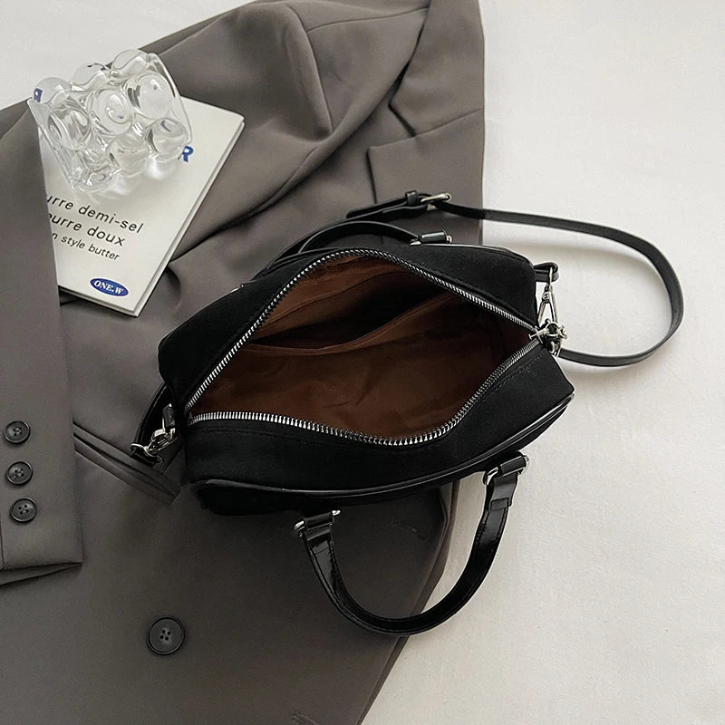 Ouverte sur une doublure marron, la fermeture à glissière du sac noir dégage un large accès
