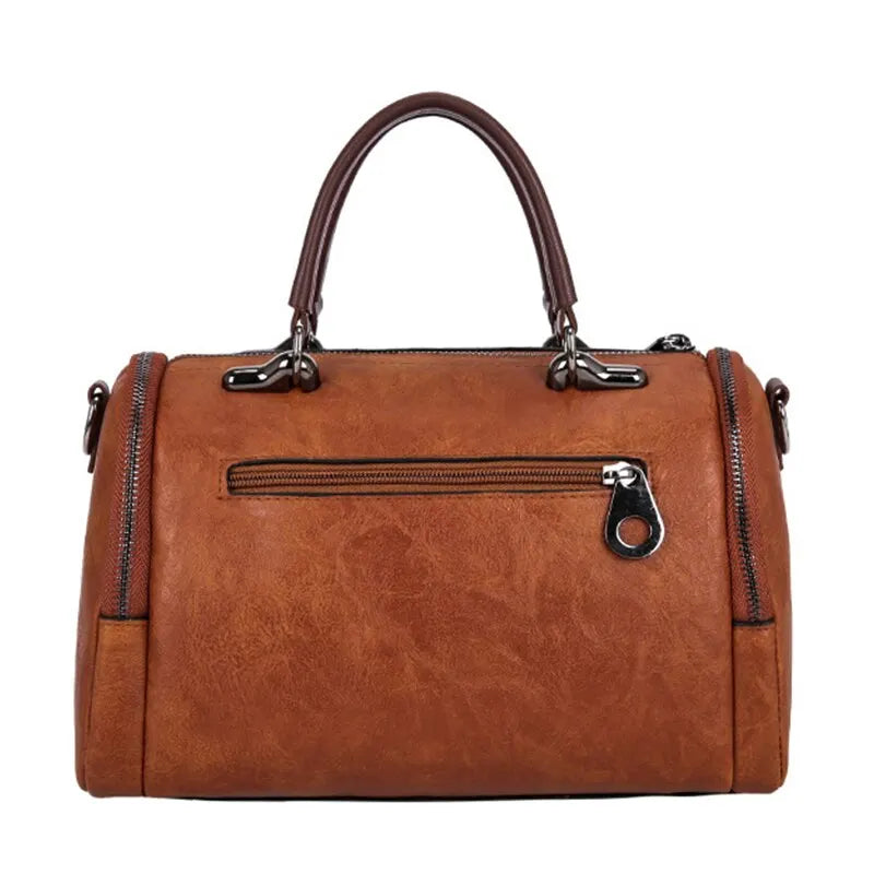 Dos du sac boston cognac avec sa poche zippée horizontale et ses deux fermetures de côté