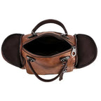 Ouverture zippée du sac cognac prise en plongée, doublure sombre et flancs latéraux dépliés