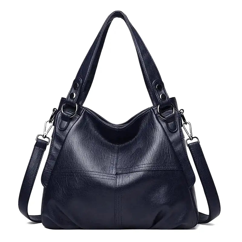 Bleu marine profond, silhouette hobo aux flancs plissés, anneaux argentés et longue bandoulière