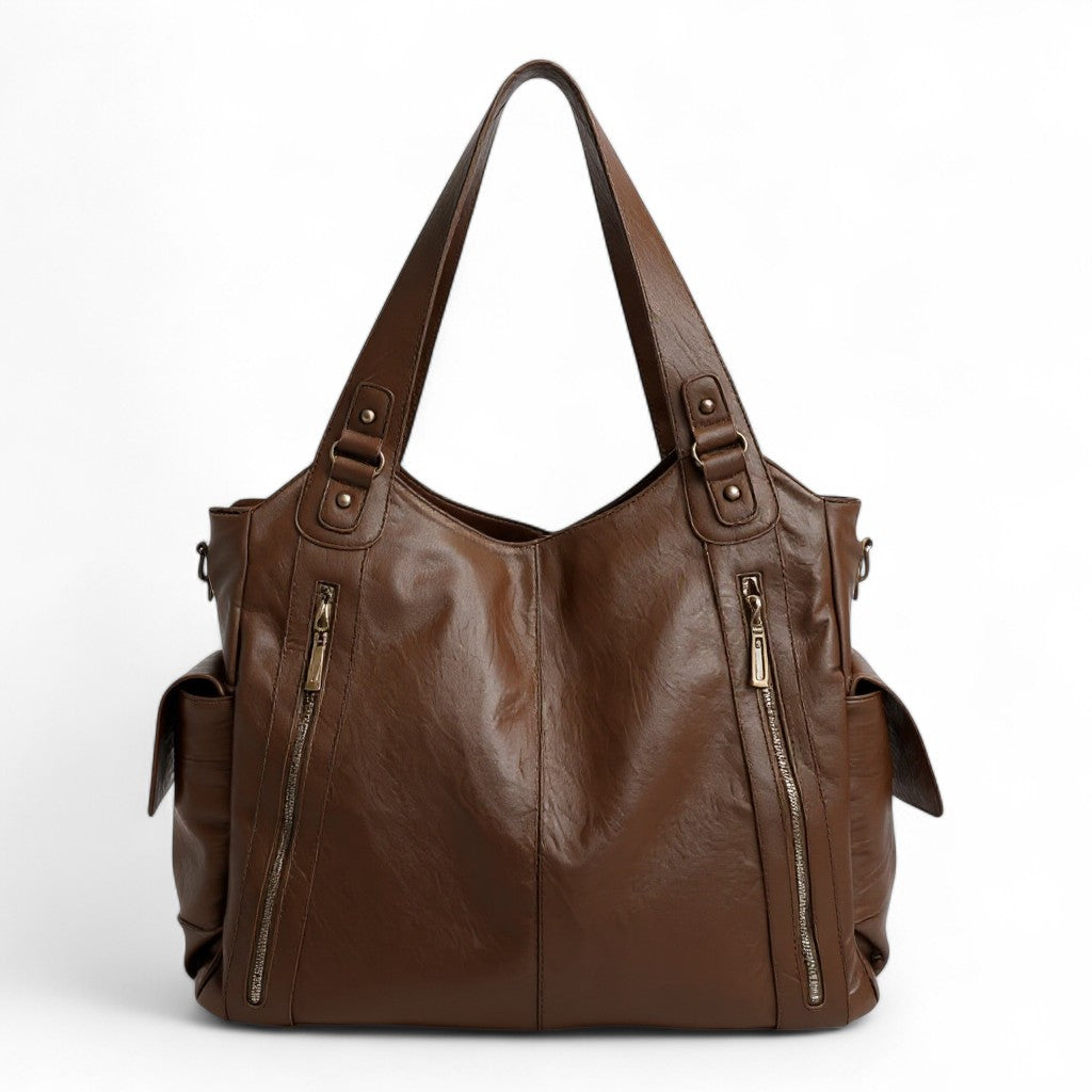 Marron chaud sur ce grand sac d'épaule pris de face, fermetures à glissière et pattes à rivets
