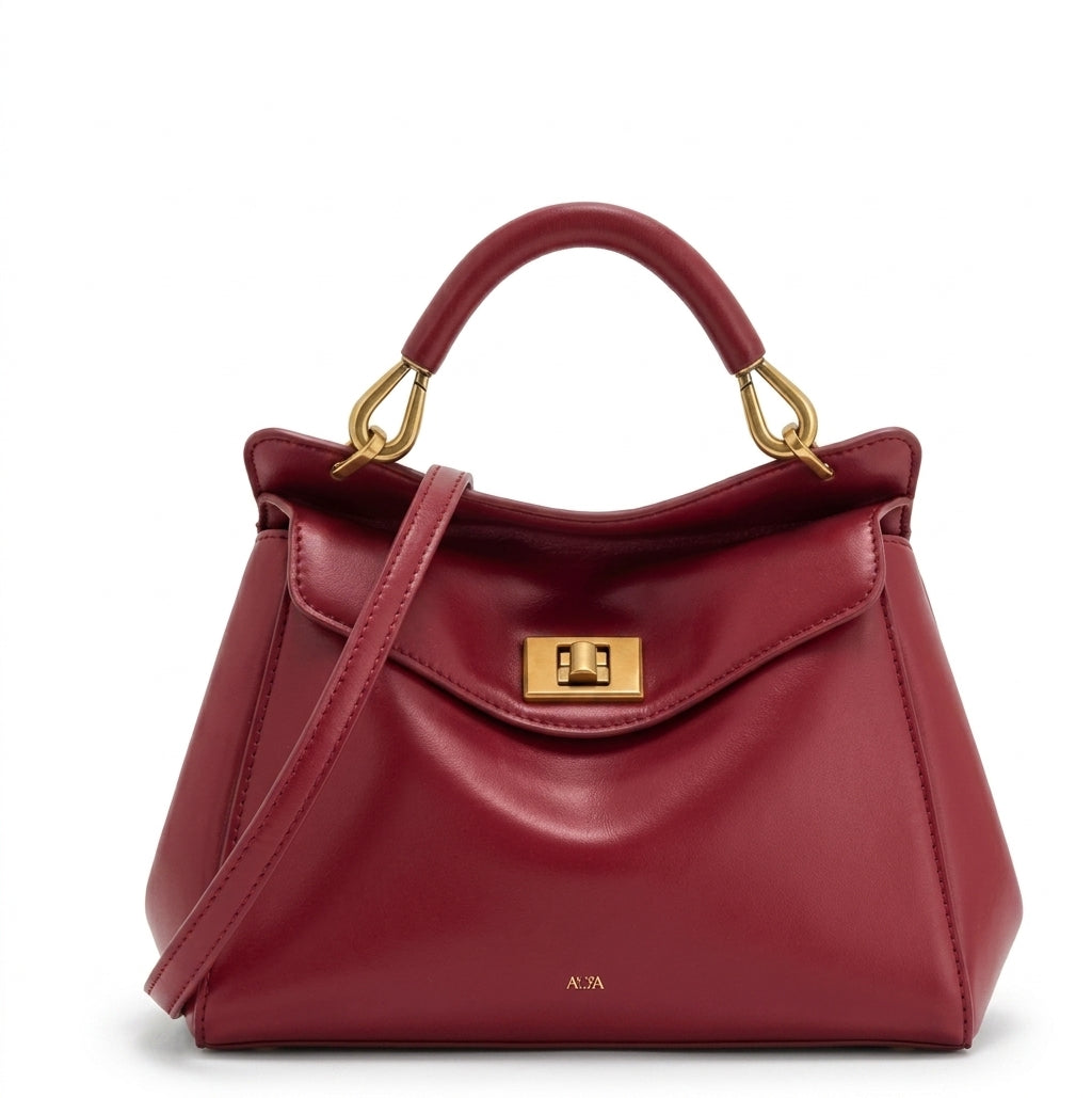 Rouge bordeaux, ce sac à main structuré à rabat et fermoir tourniquet doré, vu de face