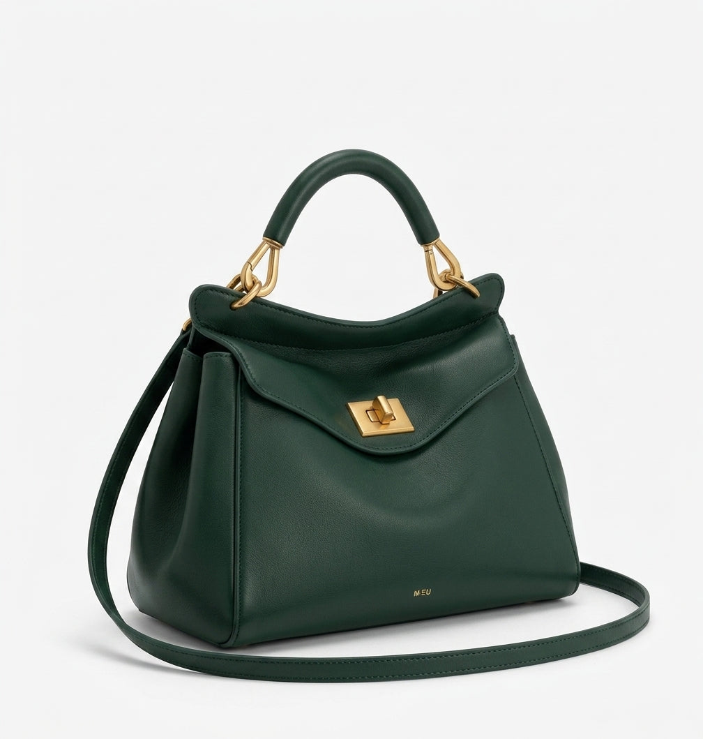 Silhouette trapèze du sac vert sapin de trois quarts, bandoulière déroulée sur le fond clair