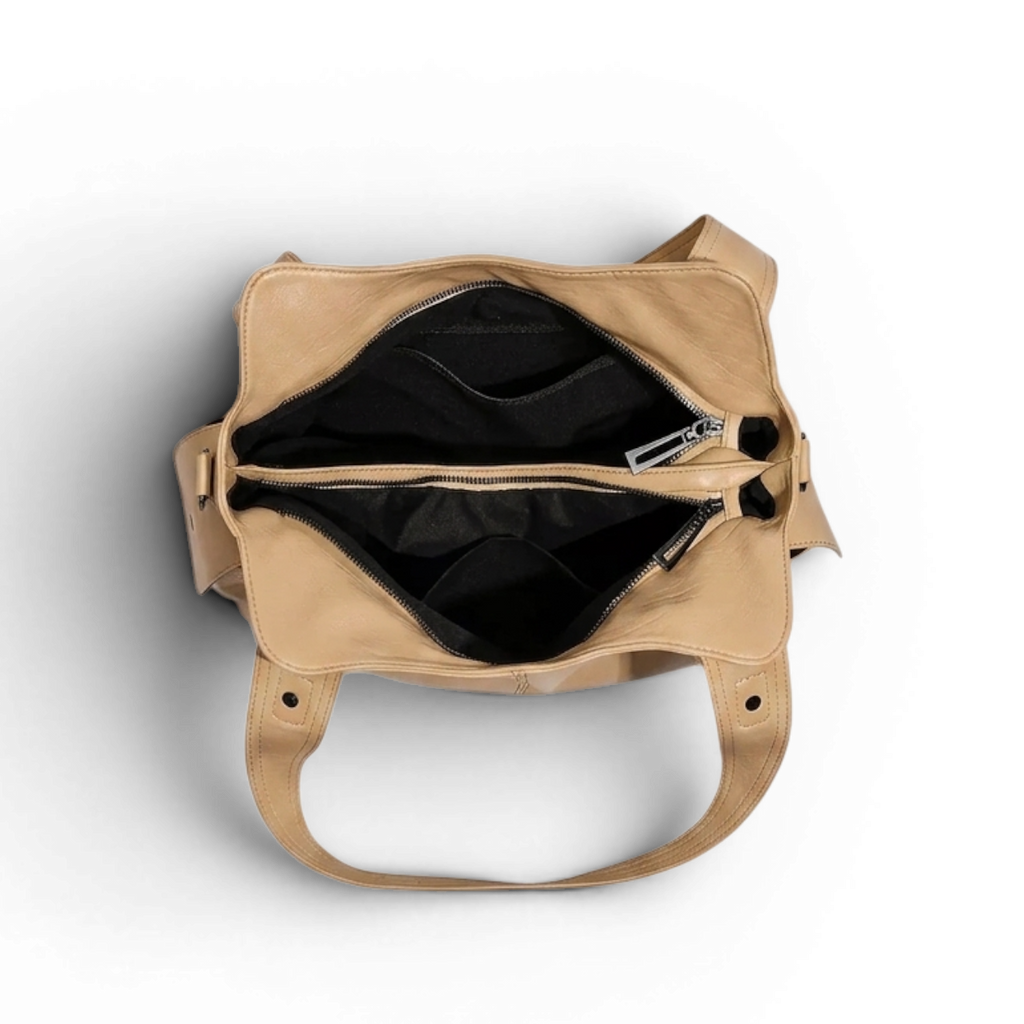 Doublure noire et deux compartiments zippés, vus de dessus sur le sac beige sable