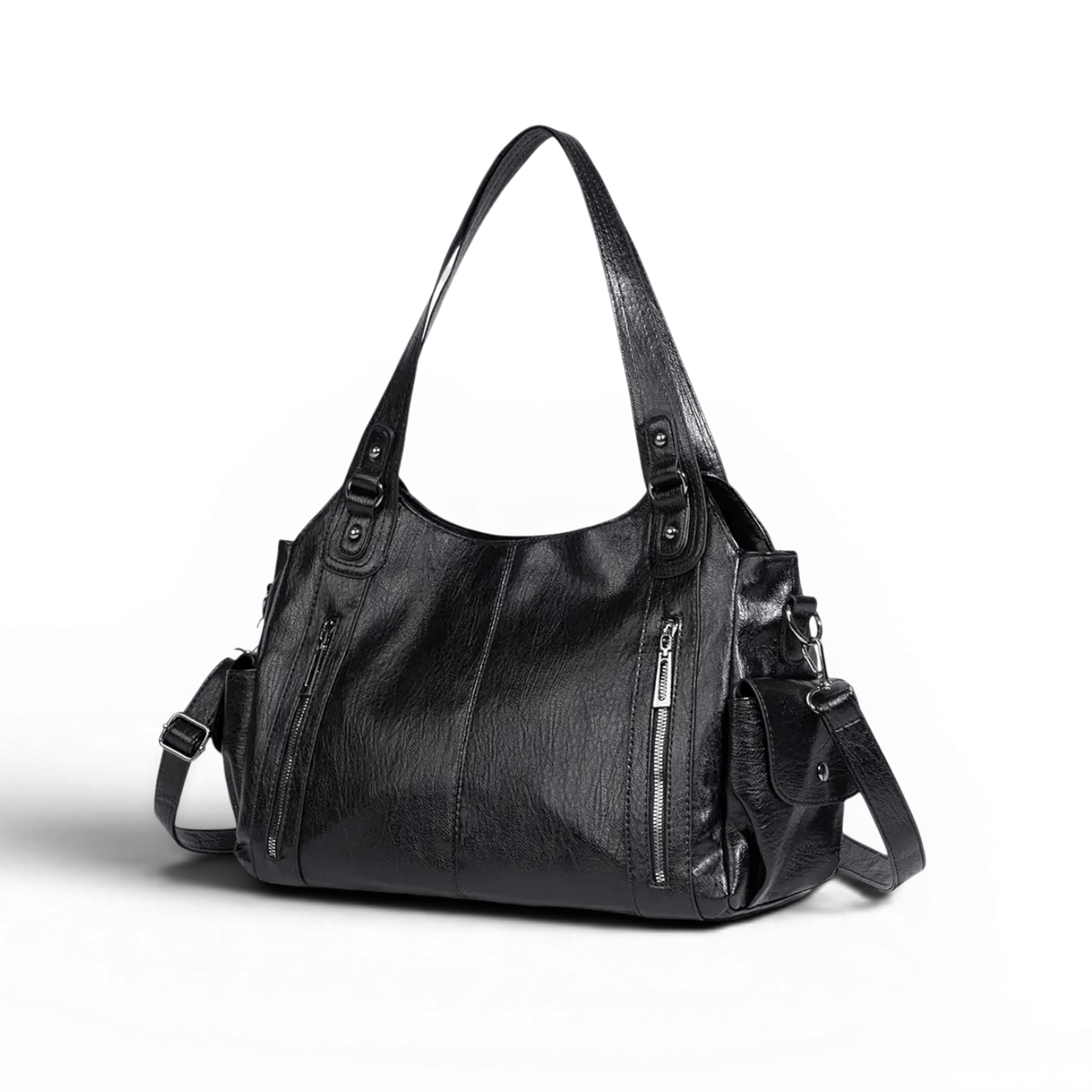 Silhouette souple du sac noir sur fond sombre, présenté de trois quarts, anses relevées