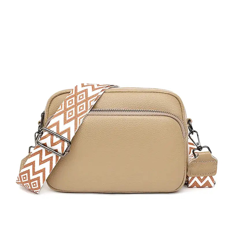 Beige sable et sangle à losanges orange, la besace compacte aligne ses deux poches zippées