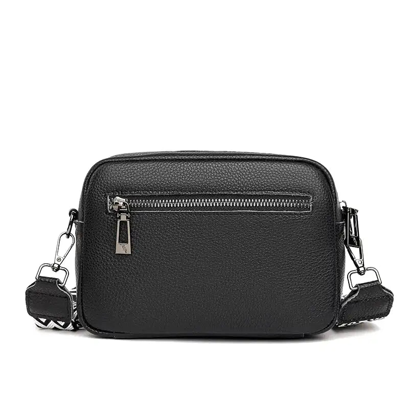 Dos du sac noir avec sa poche zippée horizontale et ses mousquetons en métal sombre