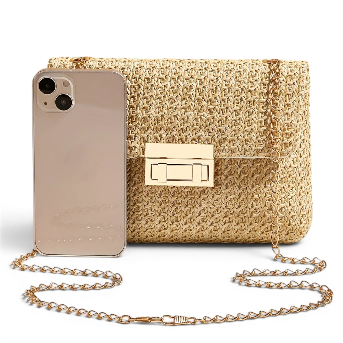 Comparaison de taille avec un téléphone posé debout contre la pochette en paille dorée
