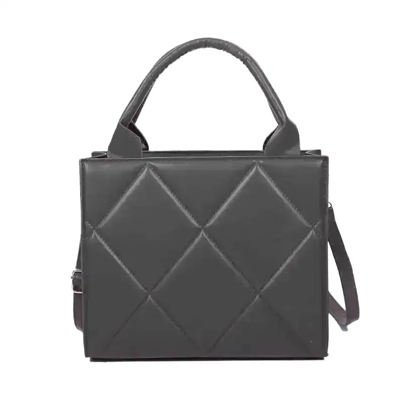 Sac à main noir matelassé en larges losanges, anse rigide et bandoulière fine, vu de face