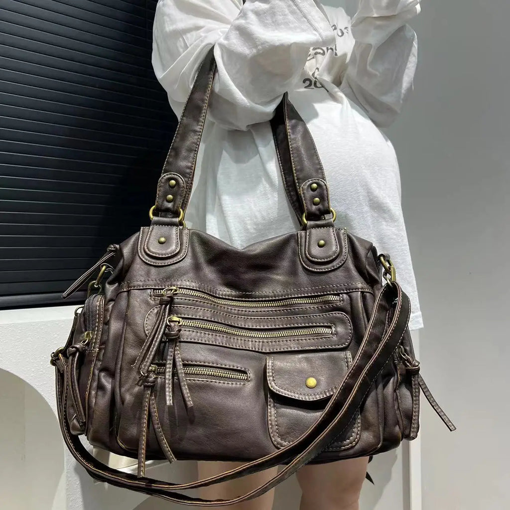 Bandoulière et anses réunies sur l'épaule, le hobo bronze irisé se porte sur une chemise blanche