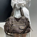 Bandoulière et anses réunies sur l'épaule, le hobo bronze irisé se porte sur une chemise blanche