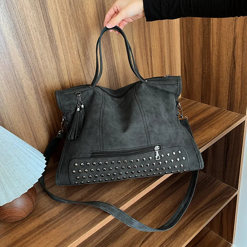 Cabas gris anthracite effet velours, rivets argentés et pompon métallique sur le côté