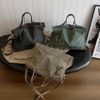 Trois coloris réunis, anthracite, vert sauge et taupe, posés sur une table basse ronde