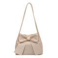Nœud surdimensionné sur ce sac seau écru en cuir végan souple, longue bandoulière fine