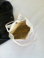 Intérieur doublé de beige clair, bouton pression doré et large ouverture du sac écru