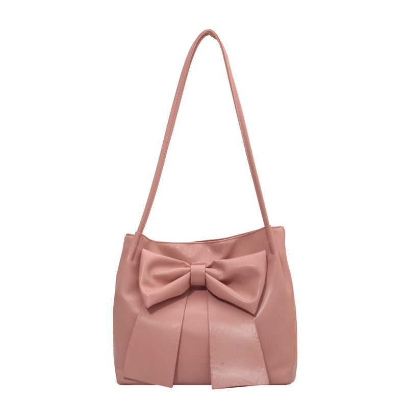 Rose poudré pour ce petit sac orné d'un large nœud, base plissée et fine bandoulière