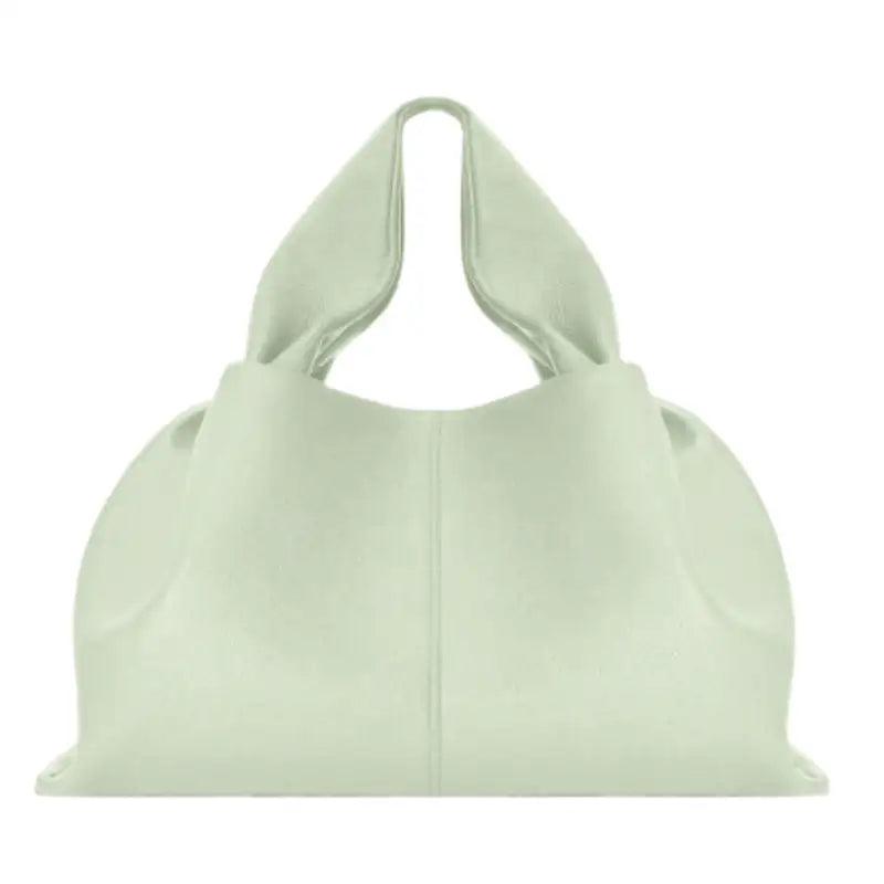 Vert amande pâle sur un sac nuage grainé, anse intégrée et plis souples, photographié de face