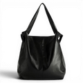 Grand cabas hobo en cuir végan noir brillant, détouré sur fond sombre, anses larges et souples
