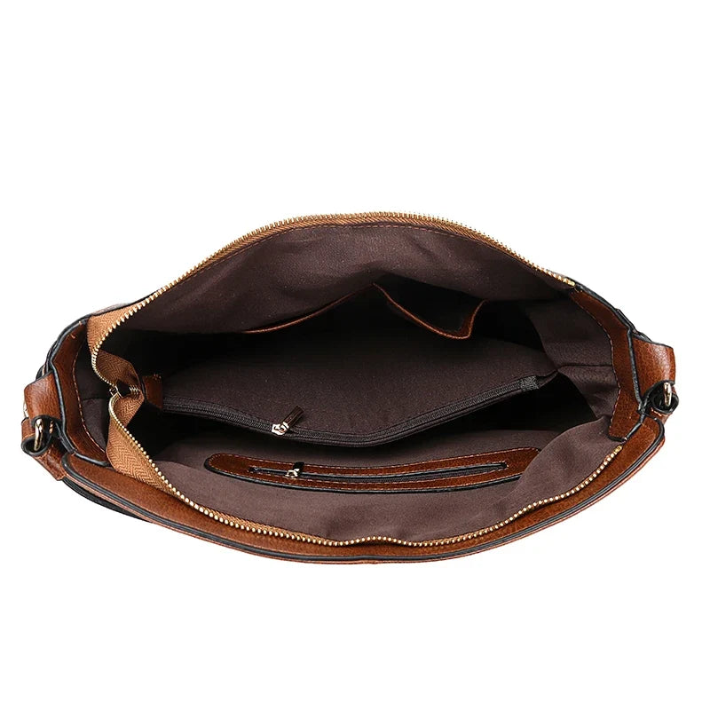 Intérieur ouvert sur une doublure brune, poche zippée plate et compartiment principal unique