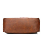 Fond rectangulaire du sac marron vu de dessous, surpiqûre périphérique et matière lisse