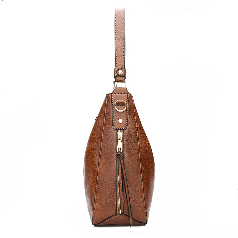 Profil étroit du sac marron, base pincée en pointe et tirette latérale sur toute la hauteur