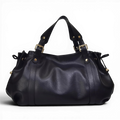 Silhouette froncée du sac noir sur fond sombre, anses doubles à boucles dorées et liens latéraux