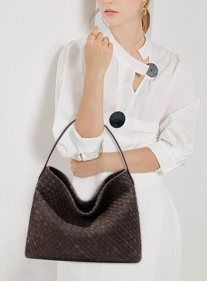 Tenu au creux du bras sur une chemise blanche, le hobo brun tressé garde une allure fluide